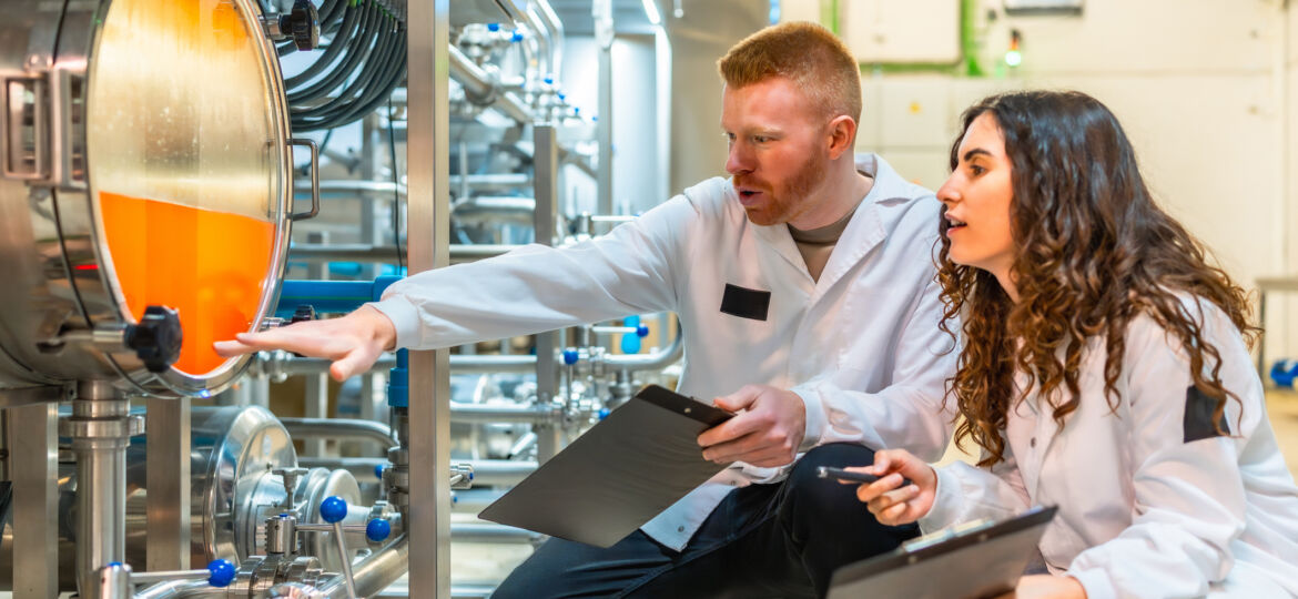 Engineers checking beer manufacturing process in a brewery factory
