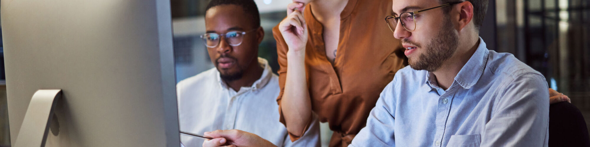 Team, office and computer in night workshop for planning, strategy or goal for business in overtime. Collaboration, teamwork and meeting at desk for creative vision, innovation or idea late at work.